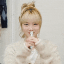 a young woman is holding a toothbrush in her hand and smiling .