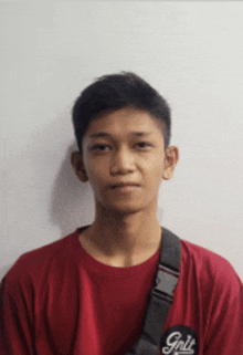 a young man wearing a red shirt with the word grit on the front