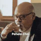 a man with glasses and a beard is drinking a cup of tea with the caption pehele chai