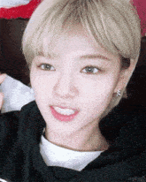 a close up of a woman 's face with a black hoodie and a white t-shirt