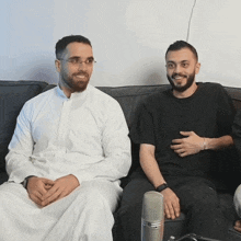 two men sit next to each other on a couch