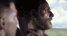 a man with a beard is sitting in the back seat of a car looking out the window .