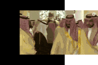 a group of men in traditional arabic clothing are standing next to each other in a room .