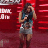 a woman with blue hair is holding a microphone and wearing a belt that says intercontinental champion