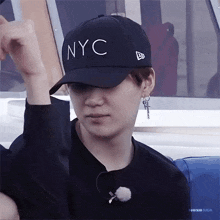 a young man wearing a black nyc baseball cap