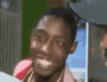 a close up of a man 's face making a funny face in front of a refrigerator .