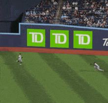 a baseball game is being played in front of a tdd sign