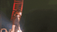 a man stands on a stage in front of a stack of speakers with the letter d on the bottom