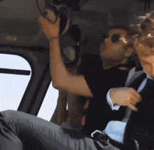 a man in a suit and sunglasses is sitting in a helicopter