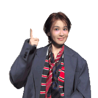 a woman wearing a suit and striped scarf is pointing up