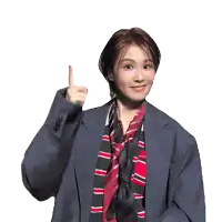 a woman wearing a suit and striped scarf is pointing up