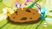 a cartoon of ponies standing around a cookie with the words all new hub on the bottom
