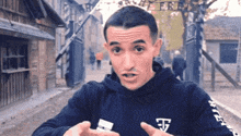 a man wearing a black hoodie with the letter e on the arm