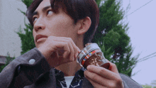 a young man is holding a jar that says ' coca cola ' on the front
