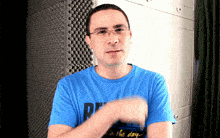 a man wearing glasses and a blue shirt that says rf on it