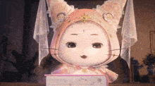 a stuffed animal with a hood and a star on its head is holding a book
