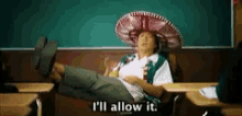 a person wearing a sombrero is laying on a couch in a classroom .