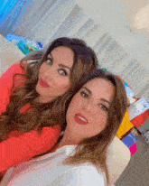 two women are posing for a picture and one of them is wearing a red shirt