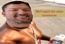 a man with a beard is smiling in front of a sign that says we 'll watch the video tomorrow