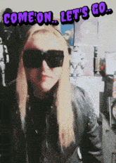 a woman wearing sunglasses and a black jacket with the words come on let 's go