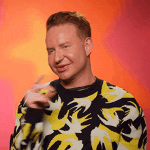 a man wearing a yellow and black sweater with the letter r on the front