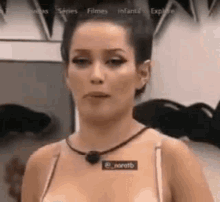 a woman is standing in front of a mirror wearing a necklace and a bra .