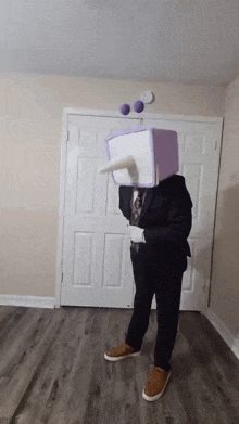 a man in a suit and tie is wearing a costume with a box on his head .