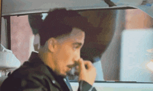 a man with a beard is sitting in the back seat of a car