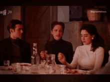 a group of people are sitting at a table with a sign that says agries melia