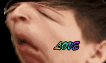 a close up of a man 's face with the word love on his face