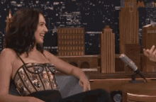 a woman in a corset is sitting in front of a microphone with a city in the background