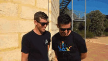 two men standing next to each other with one wearing a shirt that says " liv "