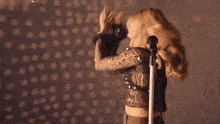 a woman is singing into a microphone and dancing