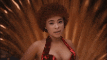 a woman with red curly hair is wearing a red dress