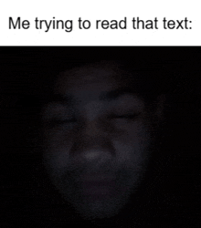 a man 's face is shown in the dark with the words me trying to read that text below it
