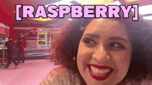 a woman is smiling with the word raspberry above her