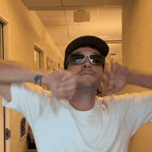 a man wearing sunglasses and a baseball cap is making a funny face