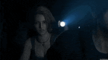 a man and a woman are standing next to each other in a dark room with a flashlight .