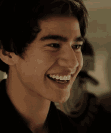 a close up of a young man 's face with a smile