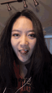 a woman sticking her tongue out and wearing a shirt that says ua7
