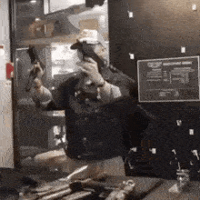 a man in a mask is holding a gun in a room .