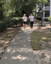 a man and a woman are walking down a sidewalk