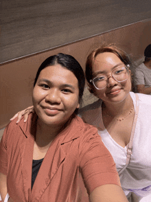 two women are posing for a picture together and one has glasses on