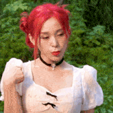a woman with red hair wearing a choker and a white top