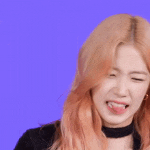 a woman with pink hair is smiling with her tongue out
