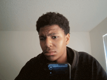 a young man takes a selfie with his phone