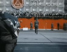 a crowd of people are gathered in front of a building that says " a "