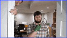 a man in a plaid shirt with a green glove on his hand
