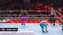 a wrestler is kneeling down in a wrestling ring in front of a referee .