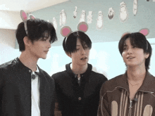 three young men wearing bunny ears are standing together